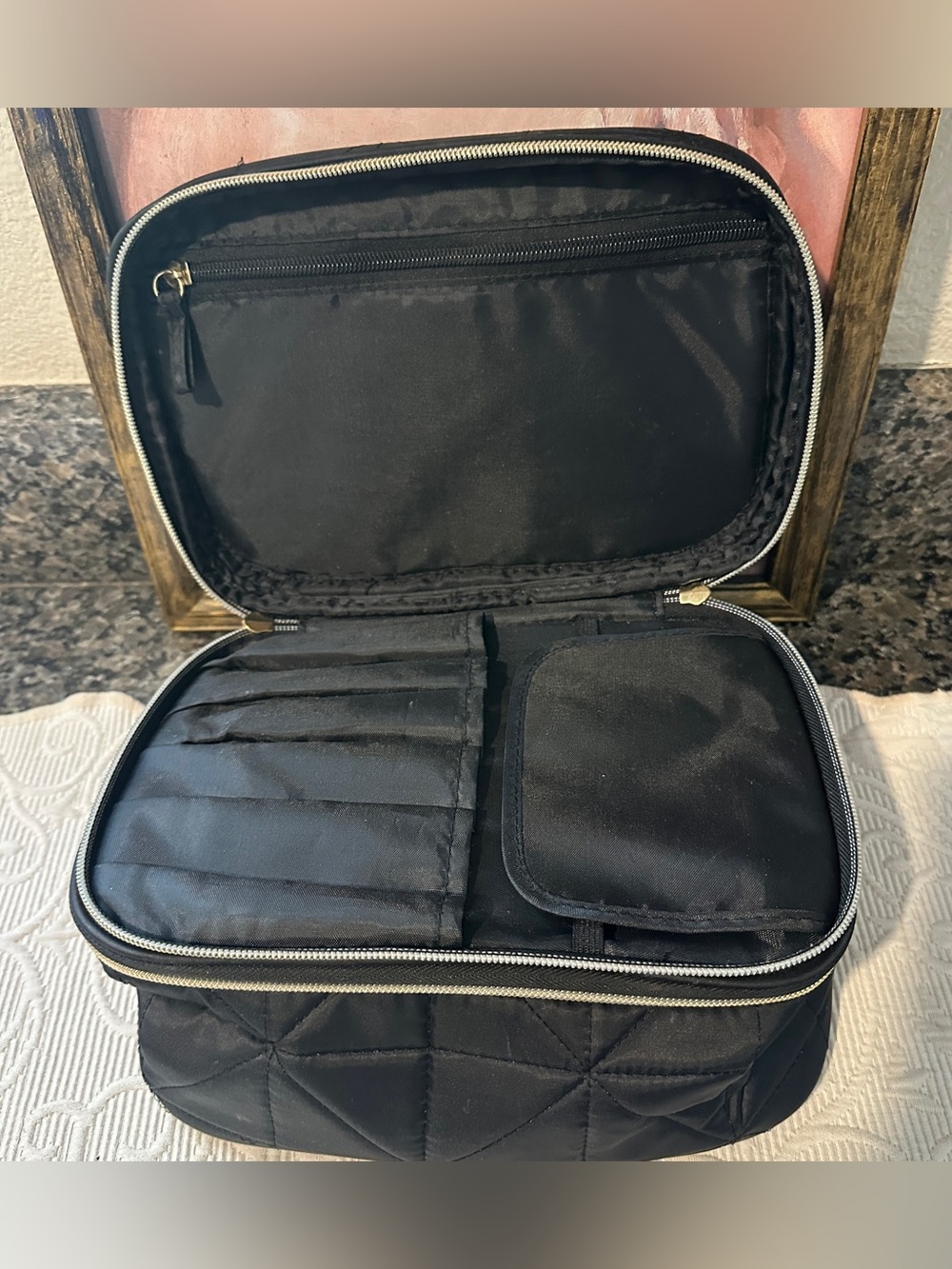 Black quilted cosmetics travel case with brush holders and pockets